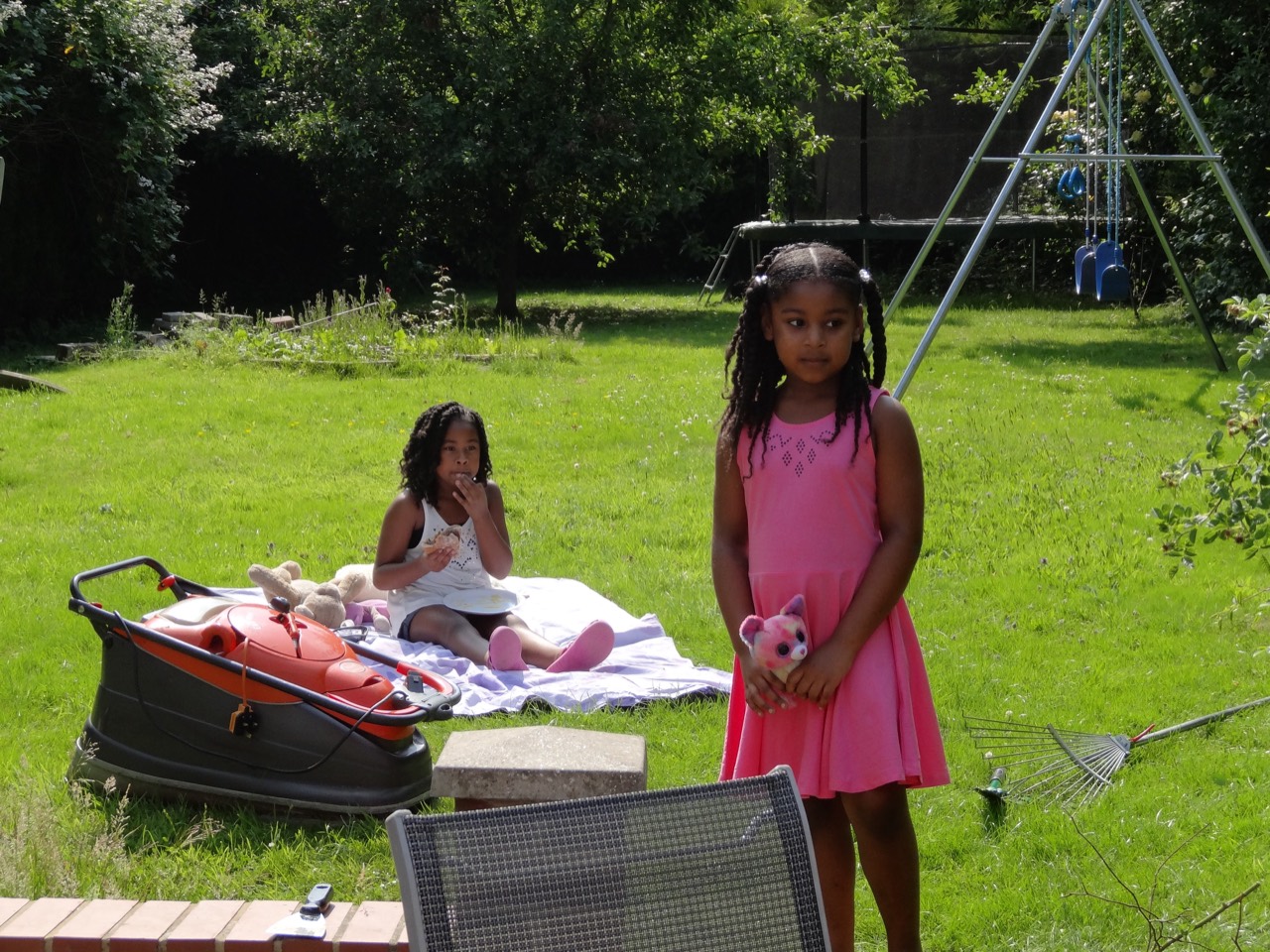 Children playing and picnicking on the garden lawn.