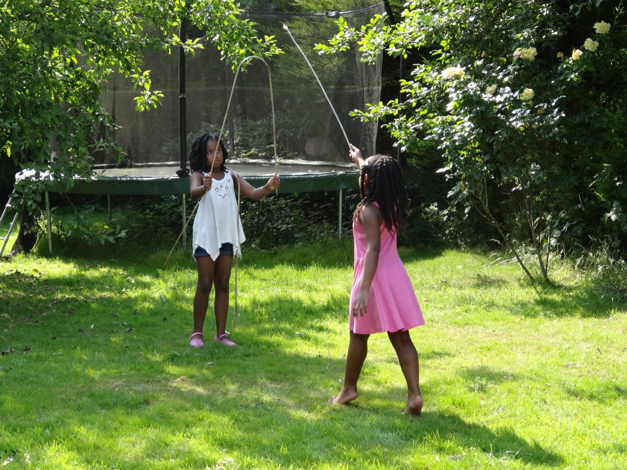 Two sisters playing with skipping ropes in the garden.